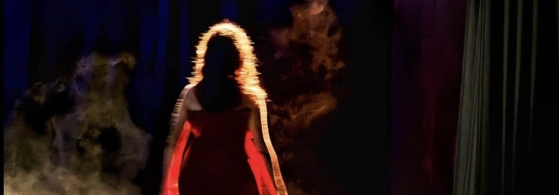 Une image d'une femme de dos, sous les projecteurs