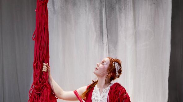 Cirque - Knitting Peace - Une artiste à côté d'une structure en fils 