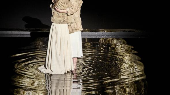 Théâtre - Les messagères - Deux femme s'enlacent devant une lune sur scène 