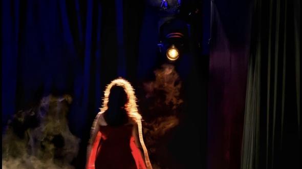 Une image d'une femme de dos, sous les projecteurs 